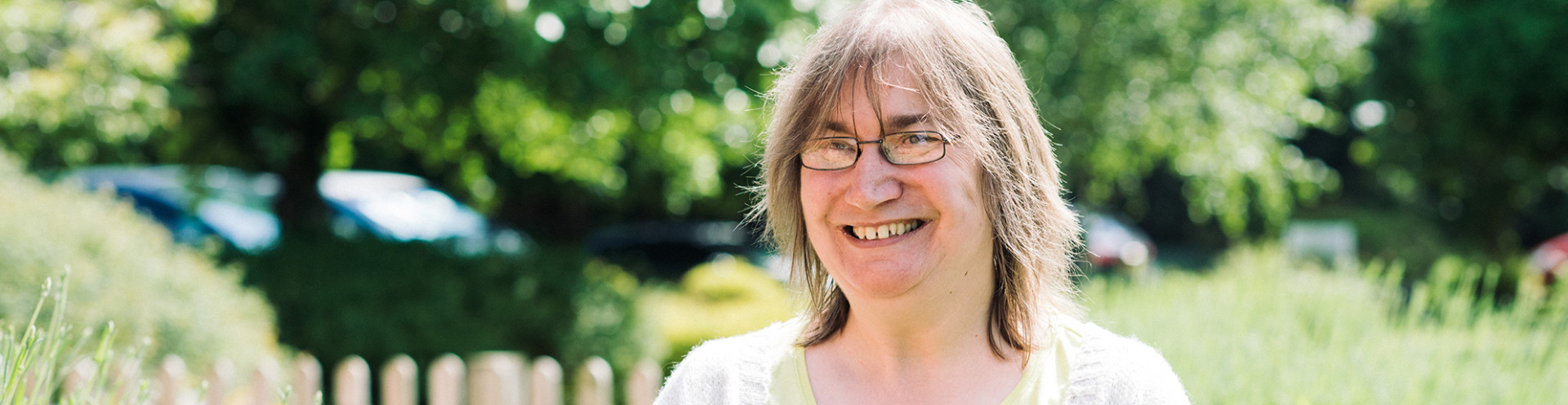 Sally smiling in a beautiful garden and giving an interview about her job.
