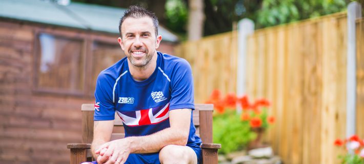 Andy Lewis smiling at the camera and sitting at the garden