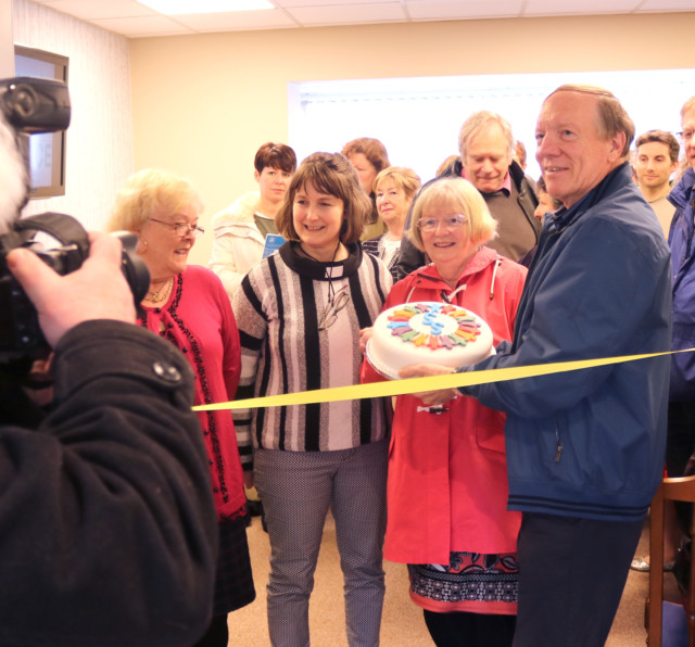 A community group together and smiling at community space opening event.