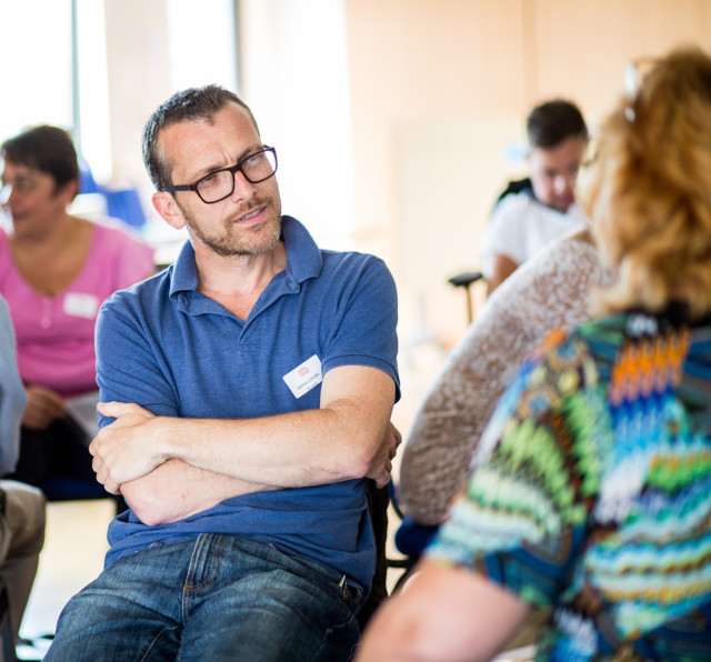 An attendee listening carefully a member who sharing her insights.