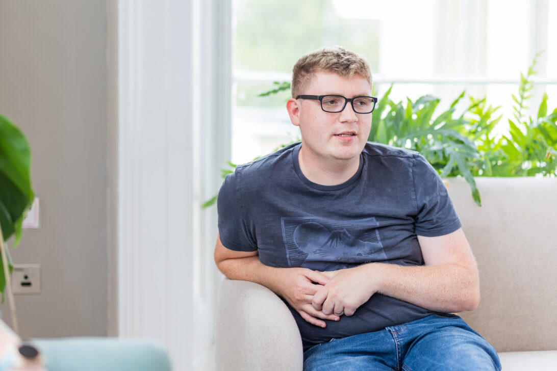 Photo of Dan Jacques, sitting on a sofa in the Barnwood Welcome area.