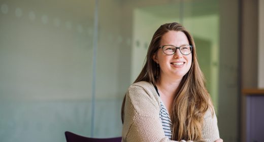 Team member Laura smiling at her desk.