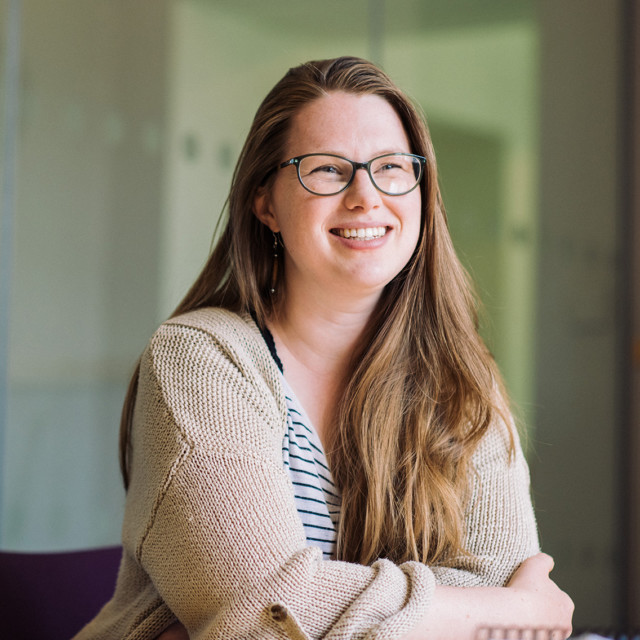 Team member Laura smiling at her desk.