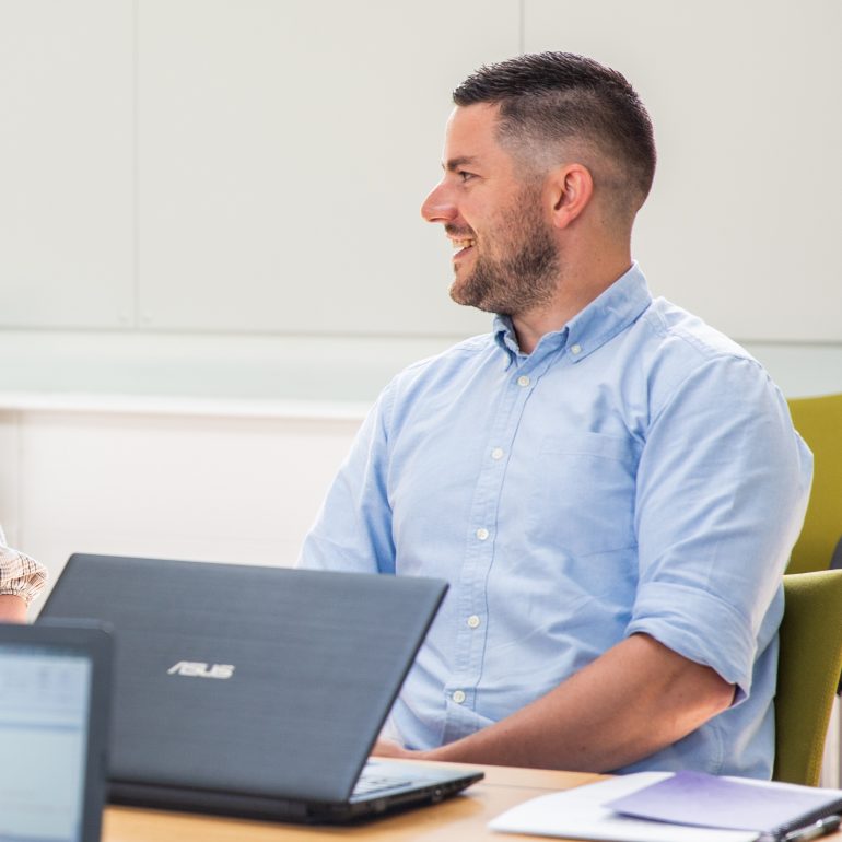 Photo of Liam Daniels, chatting to colleagues