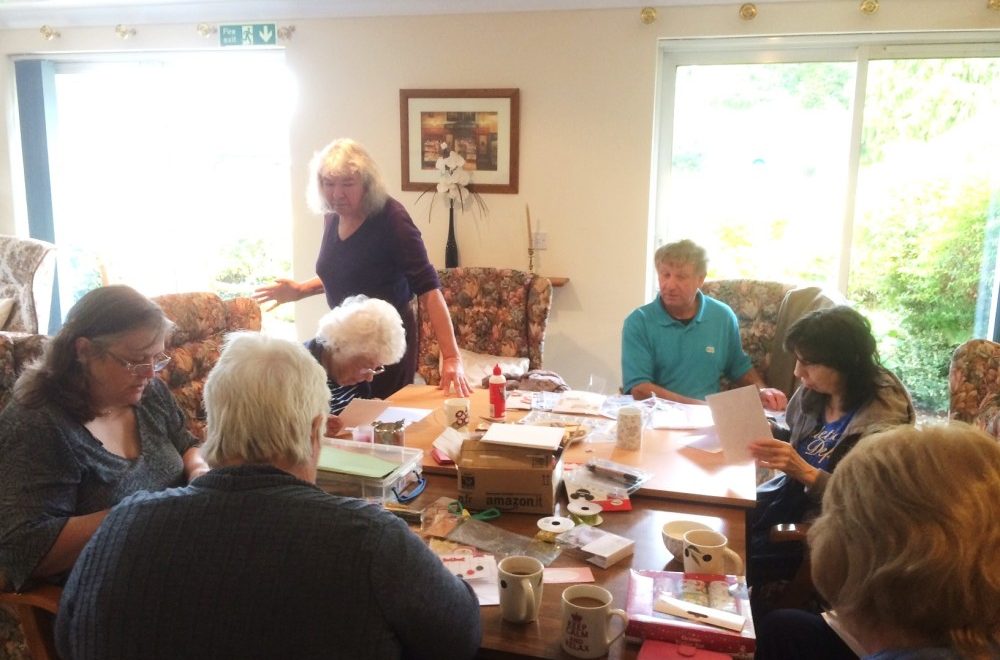 A community group at sitting at a desk for an activity.