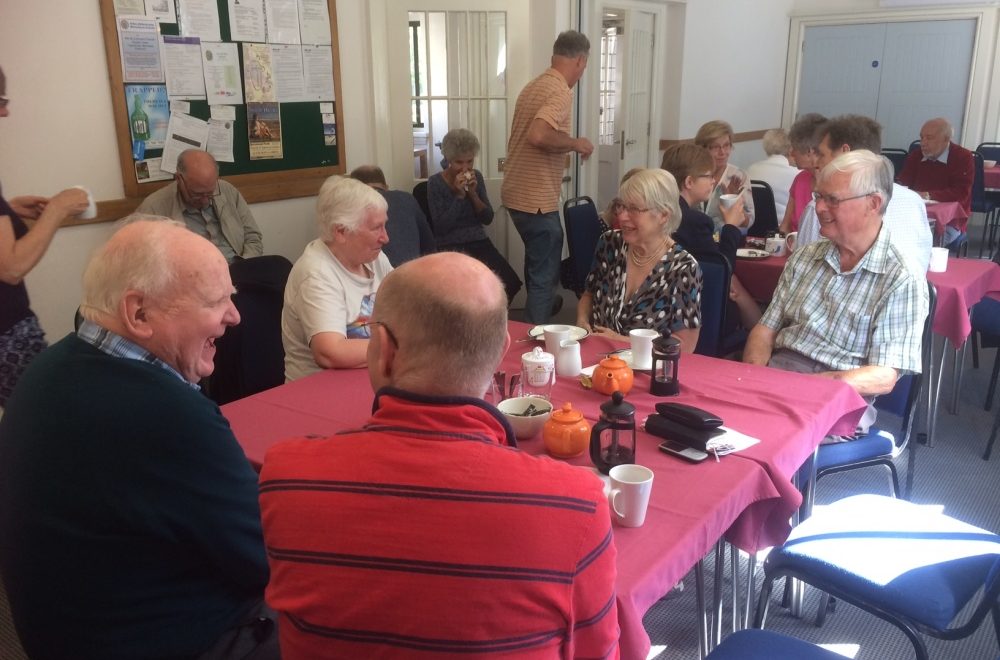 A community group having a conversation and drinking tea.