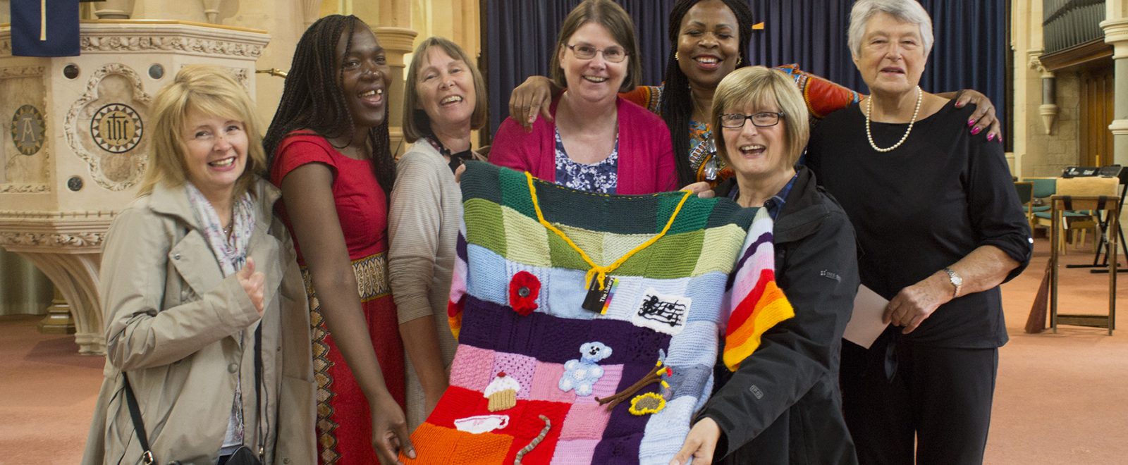 Community members showing a handmade blanket at the Community African Shield Exhibition.