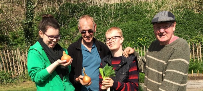 Community members showcasing their harvest at the community garden.