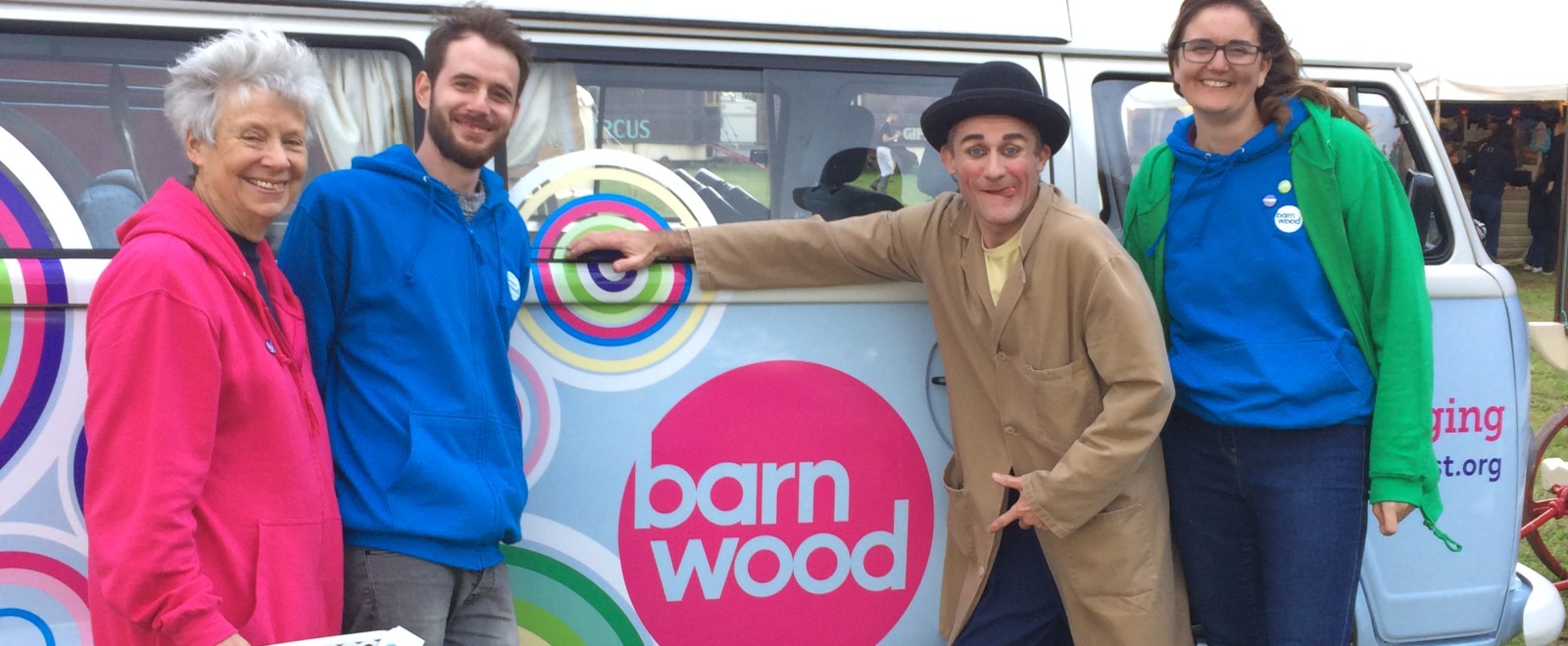 Community members smiling in front of the tour camper van