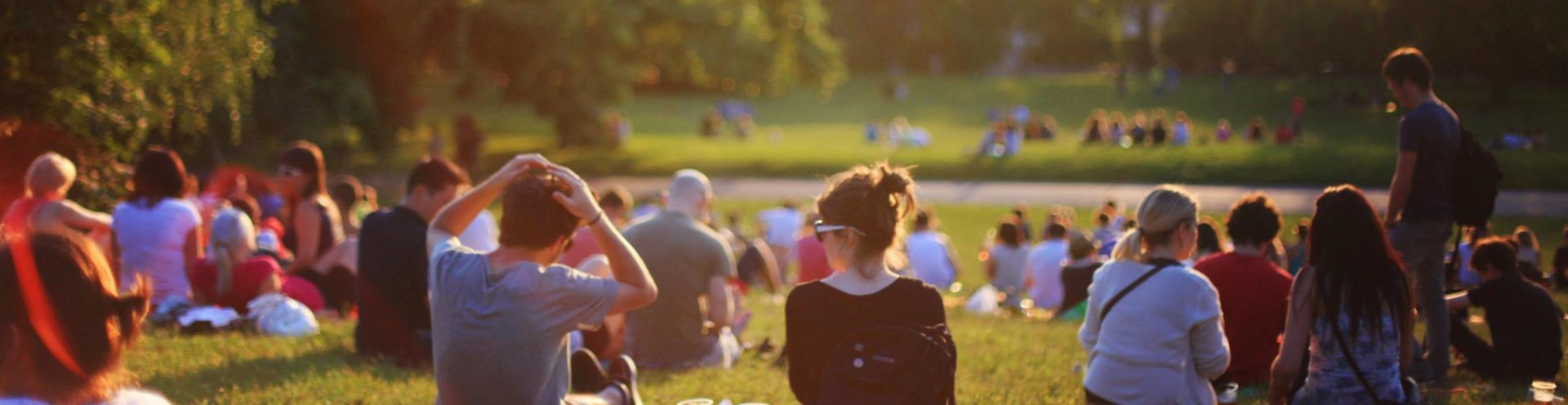 Lots of people sitting on grass in a festival