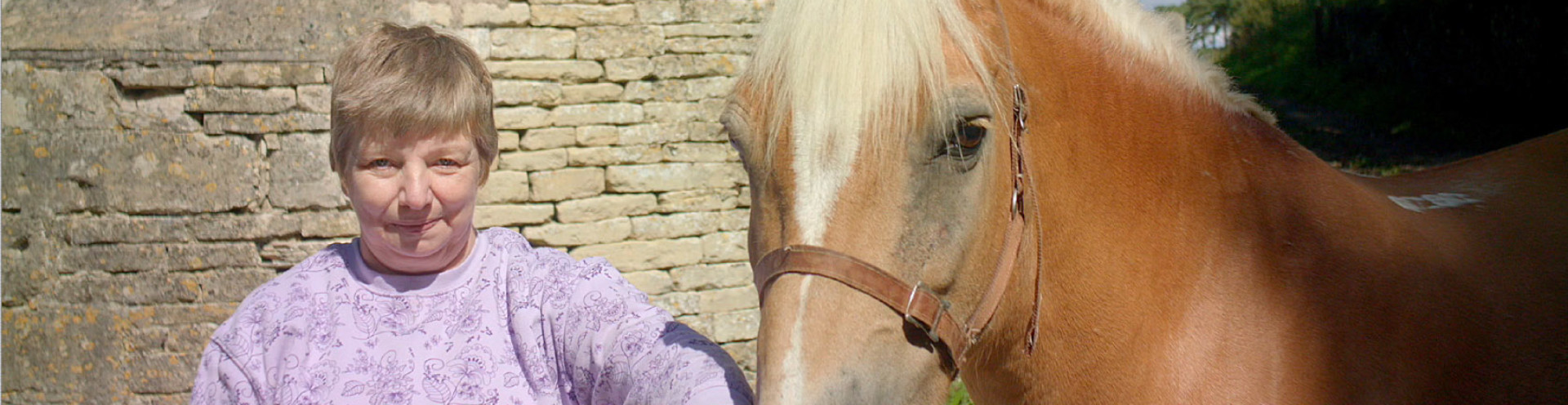 Roz standing next to beautiful horse and smiling at the camera.