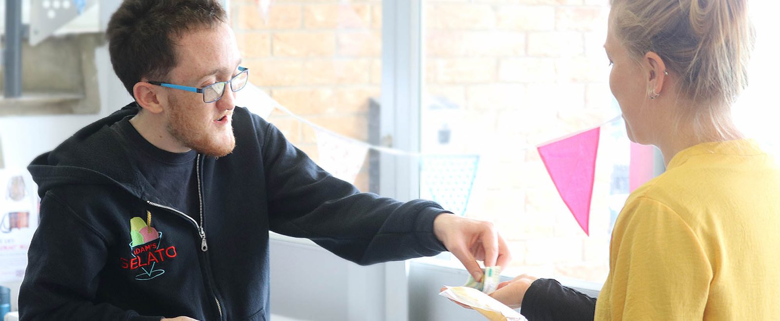 Barnwood Trust grantee Adam selling a gelato the his customer in his gelato store