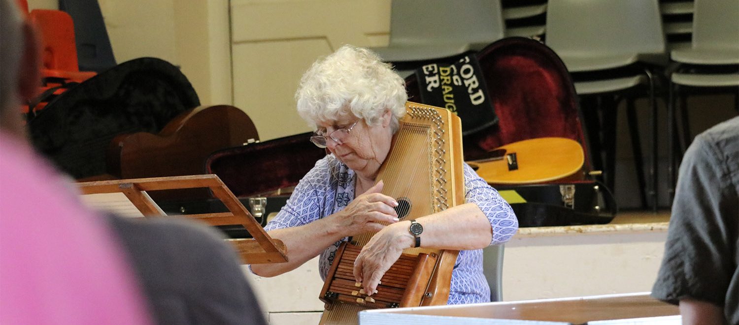 A Daylight Acoustic Club performer playing an instrument.