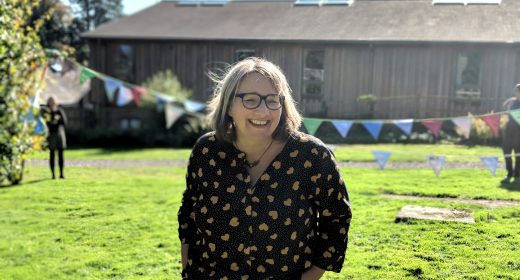 Woman smiling on the bunting flags project day.