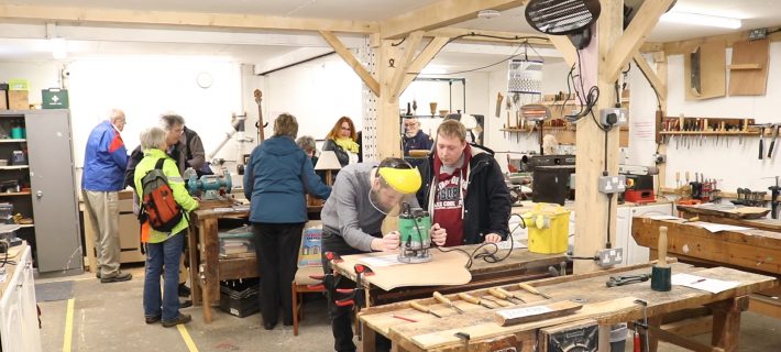 attendees working on woodwork in the community workshop