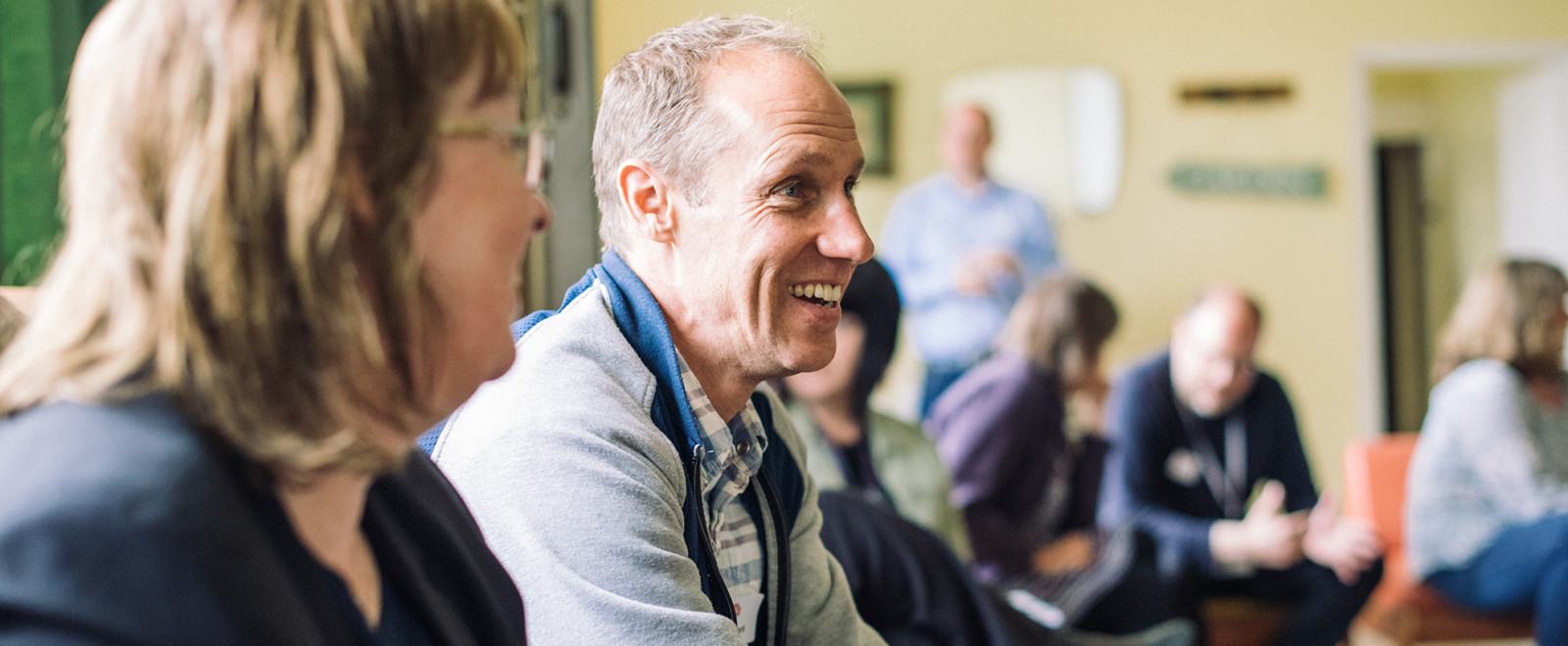 A community member sitting and smiling during a session for marketing tips and tricks for community groups