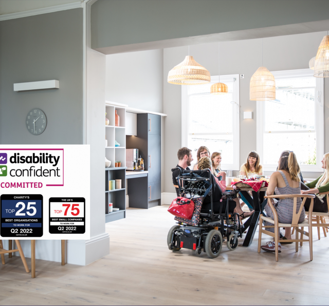 Photograph of Barnwood staff, having lunch in the kitchen on a bright sunny day. There are four logos to the left side, including Disability Confident Committed, The South West Top 50 Best companies to work for, Q2 2022, Charity's Top 25 Best Organisations to work for, Q2 2022 and The UK's Top 50 Best Small Companies to work for, Q2 2022.