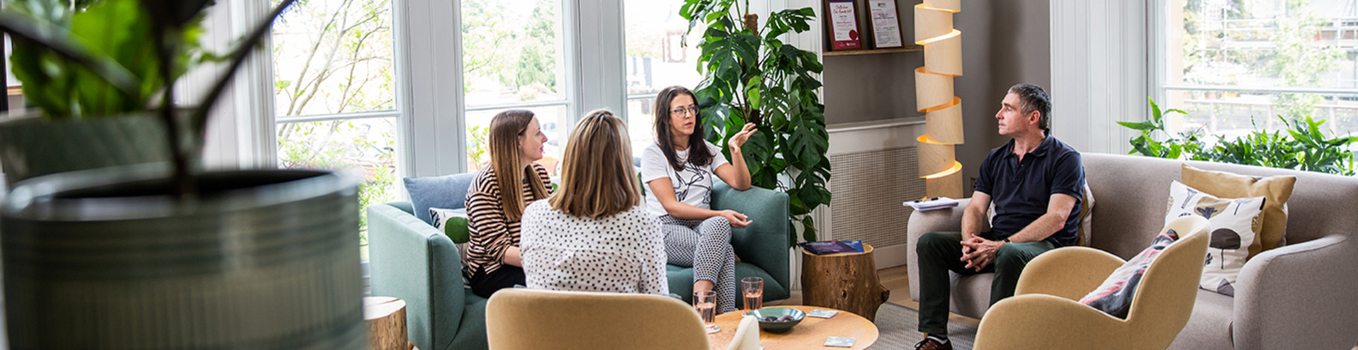 Photo of Barnwood staff talking while sitting down in the welcome area.