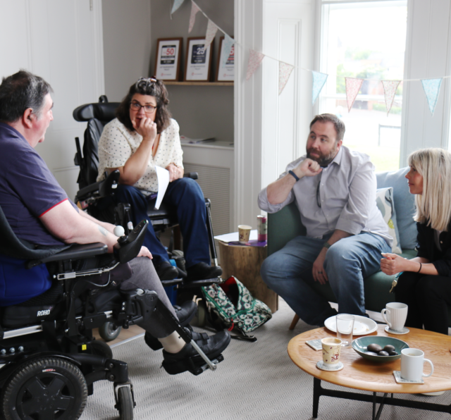 Photo of Barnwood staff and Barnwood Circle members chatting in Overton House
