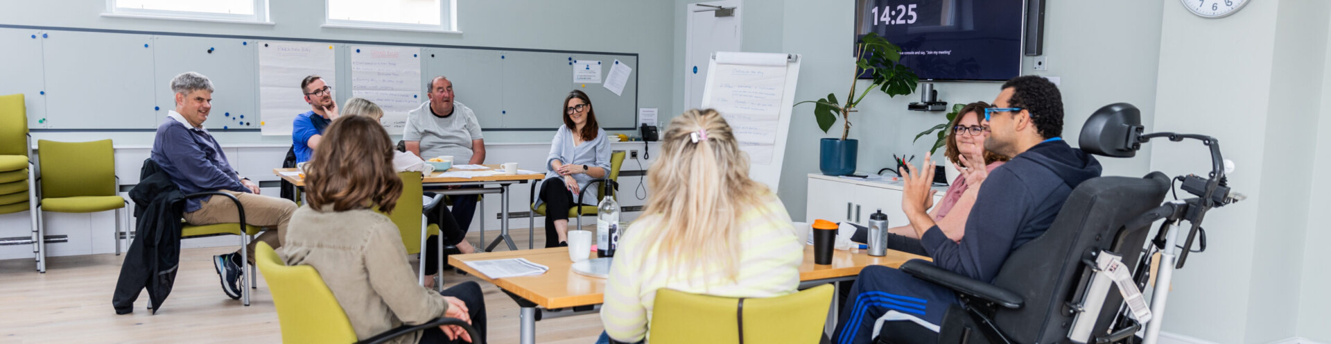 A group of Barnwood Circle members and Barnwood staff having a co-design workshop session, sat around two tables.