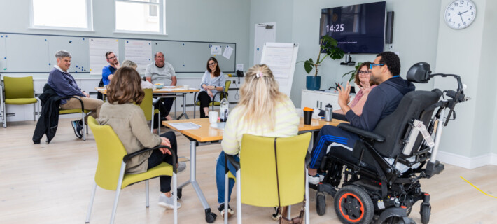 A group of Barnwood Circle members and Barnwood staff having a co-design workshop session, sat around two tables.