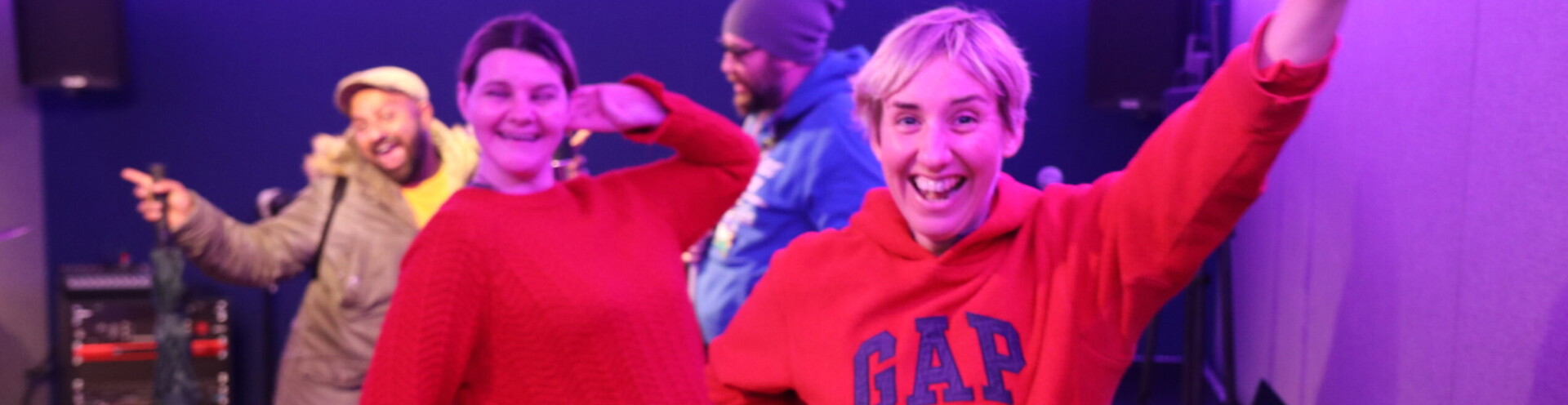 Photo of two people smiling and in the middle of dancing in a music studio