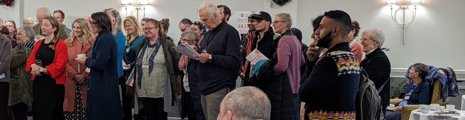 Photo of a group of people listening to a speaker in the Moat Suite at Hatherley Manor