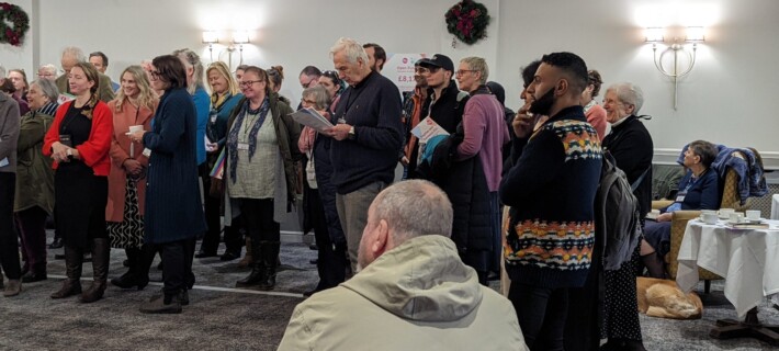 Photo of a group of people listening to a speaker in the Moat Suite at Hatherley Manor