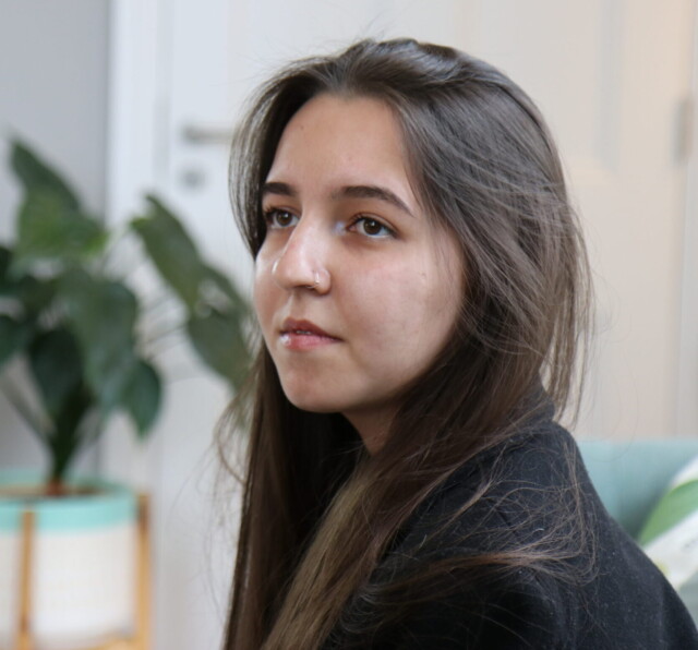 Photo of G Kadyrova, sitting on a sofa.