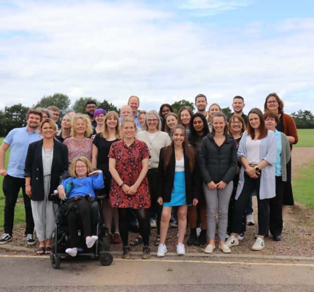 Photo shows a large group of Barnwood Trust staff posing for the camera in a group.