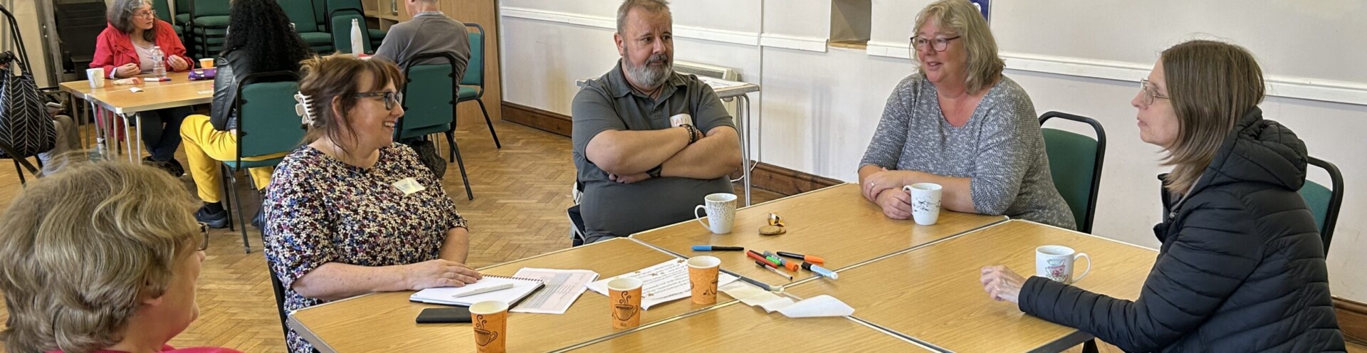 A photo of people sitting around a table and talking at a Conversation Cafe