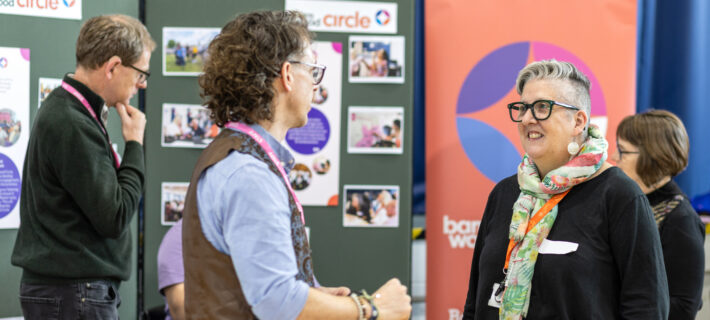 A Barnwood staff member talking to someone next to the Barnwood Circle information stall at the Annual Public Meeting